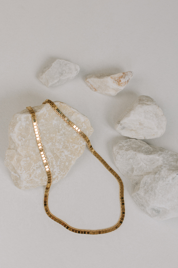 Gold Necklace on Rocks